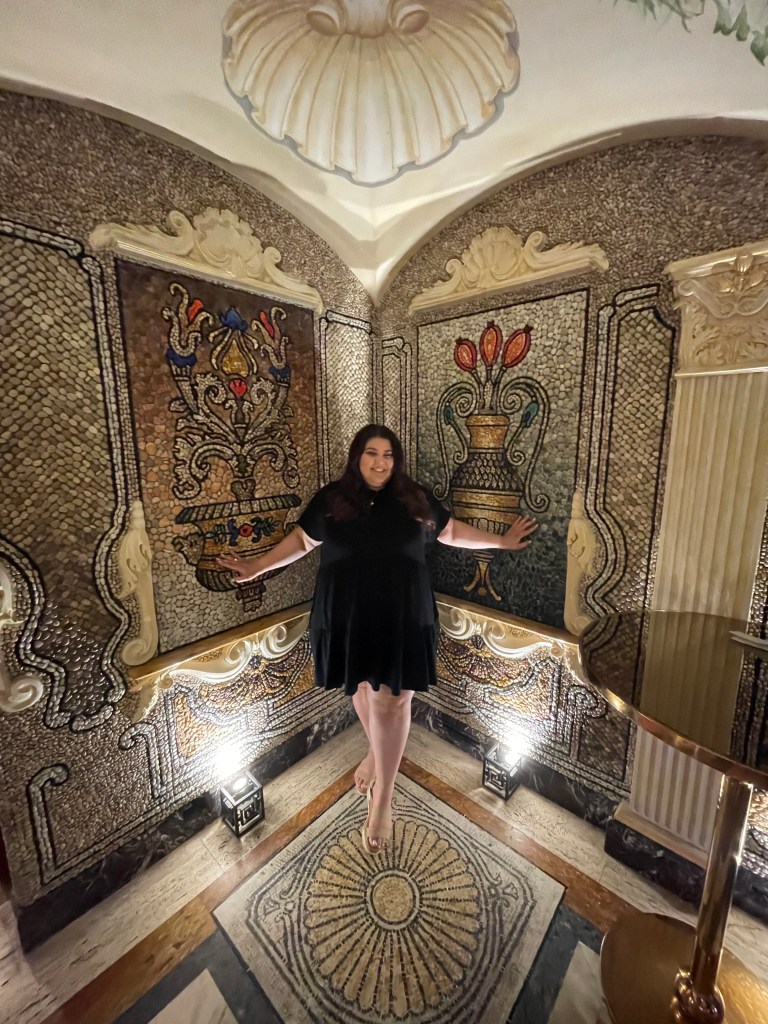 Gabby Sabat standing in a foyer surrounded by gorgeous and intricate tile pattern.