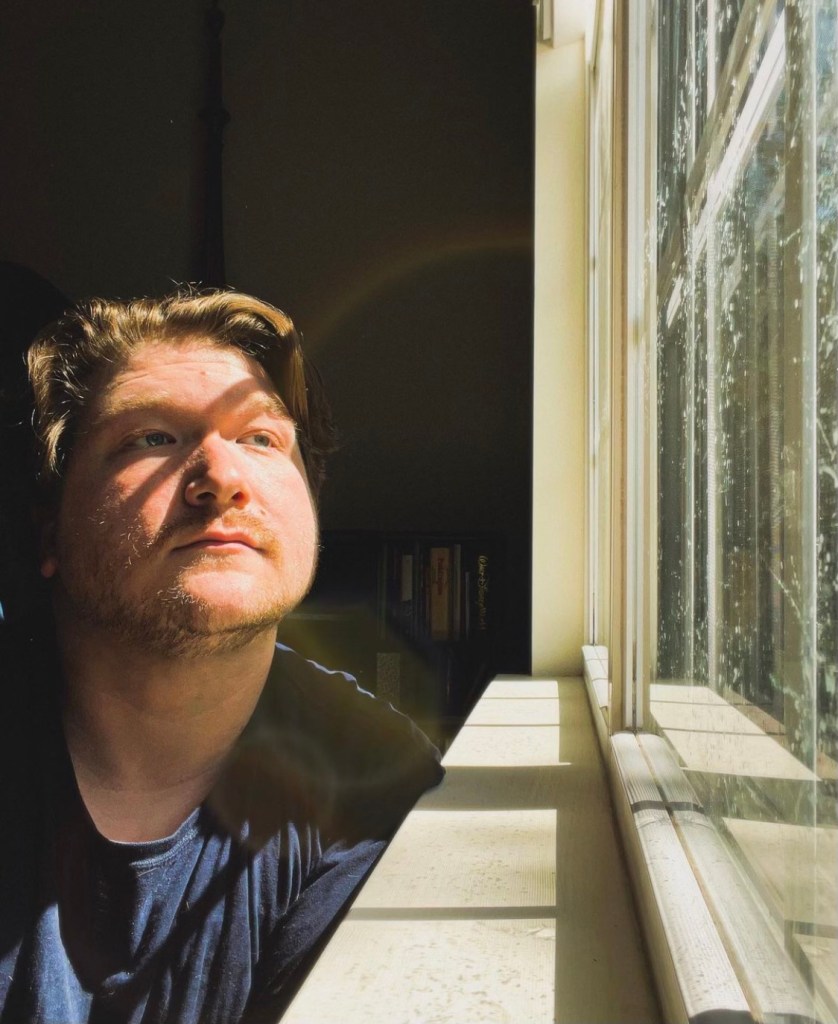 Samm being a Pisces in front of a window with gorgeous lens flares.