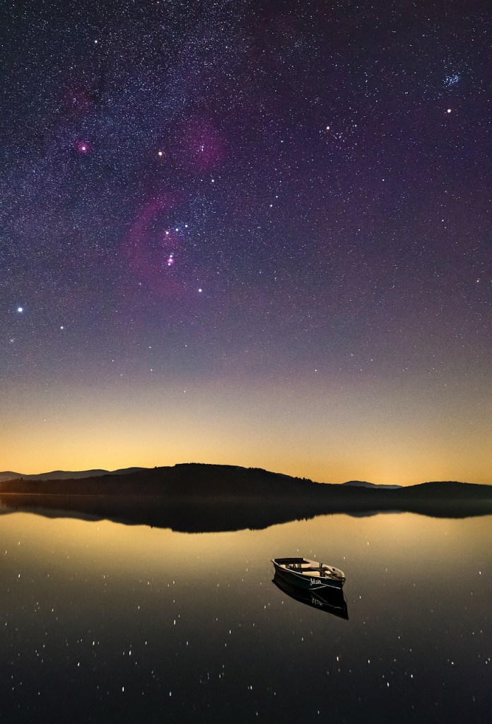 Peaceful canoe under starry night sky.